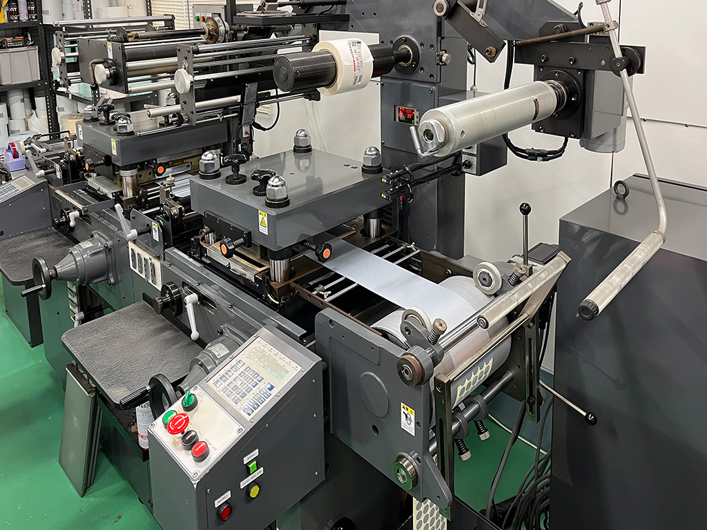 シール・ラベル印刷会社の丸紀印刷（九州工場）の設備紹介：ラベル加工機:平抜装置（箔押し装置付） HD250